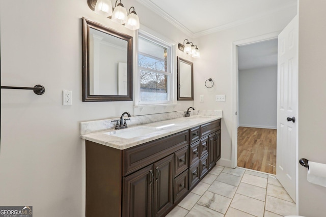 bathroom featuring baseboards, double vanity, a sink, and crown molding