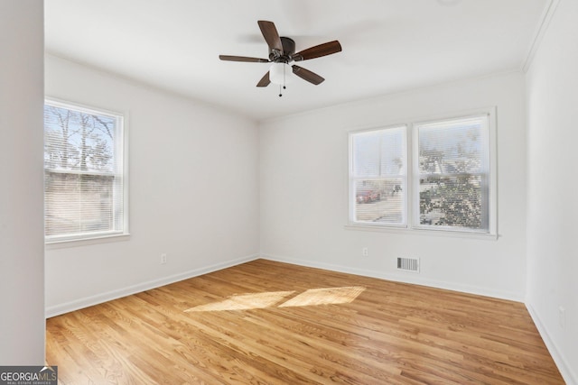 spare room with visible vents, ceiling fan, light wood-style flooring, and baseboards