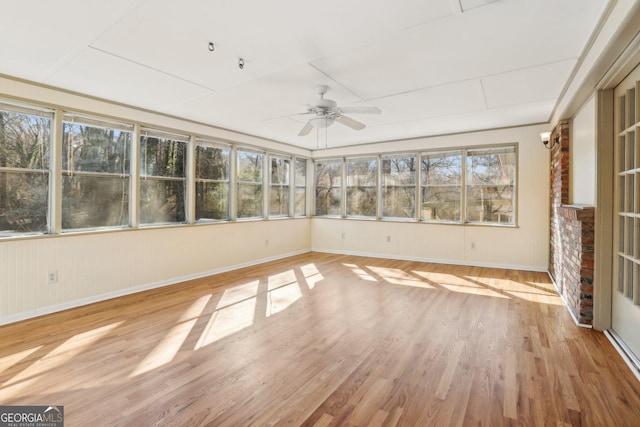 unfurnished sunroom featuring a ceiling fan