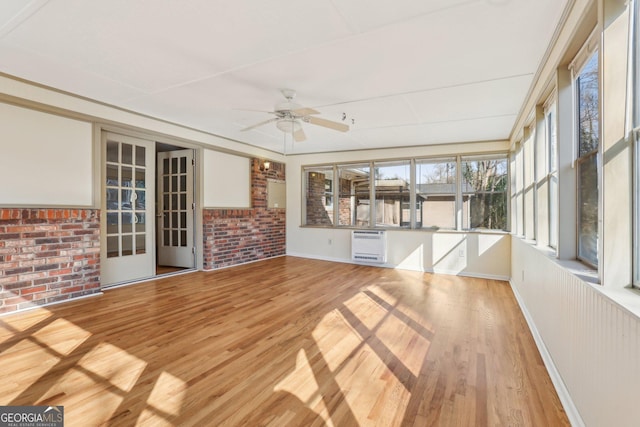 unfurnished sunroom featuring heating unit and a ceiling fan