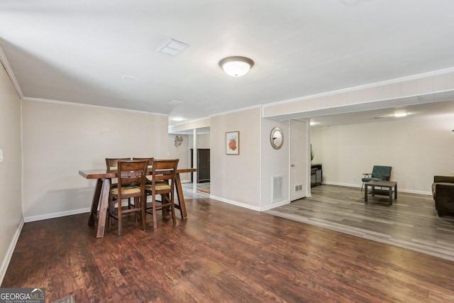 dining room featuring visible vents, crown molding, and wood finished floors