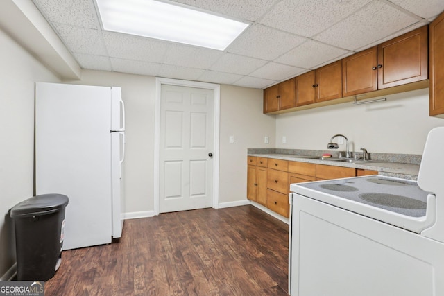 kitchen featuring brown cabinetry, white appliances, a sink, and dark wood-style flooring