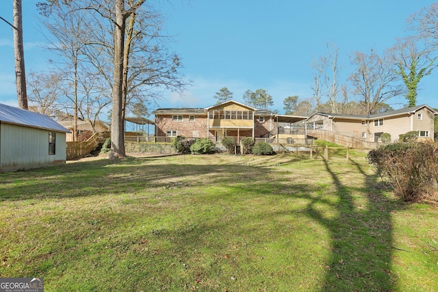 rear view of house with a yard, a fenced backyard, and a sunroom