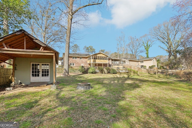 view of yard featuring an outdoor fire pit, fence, and french doors