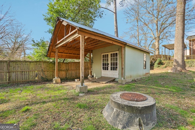 exterior space featuring an outdoor fire pit, fence, and an outdoor structure