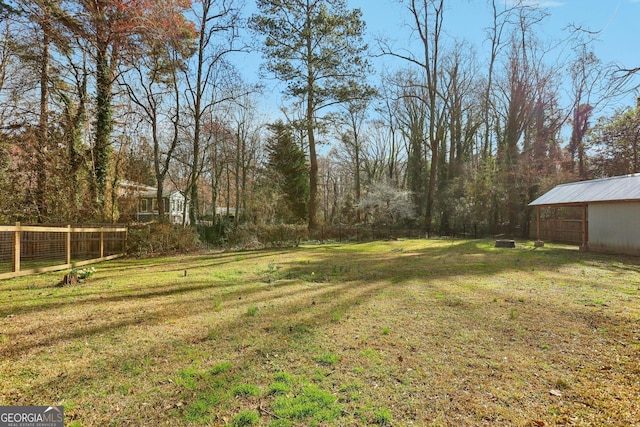 view of yard with an outbuilding and fence