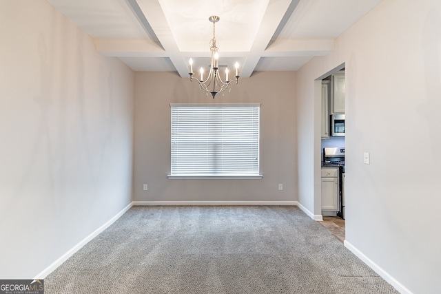 carpeted empty room featuring beam ceiling, coffered ceiling, a notable chandelier, and baseboards