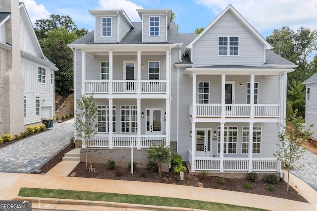 view of front of home with a balcony, a porch, and roof with shingles