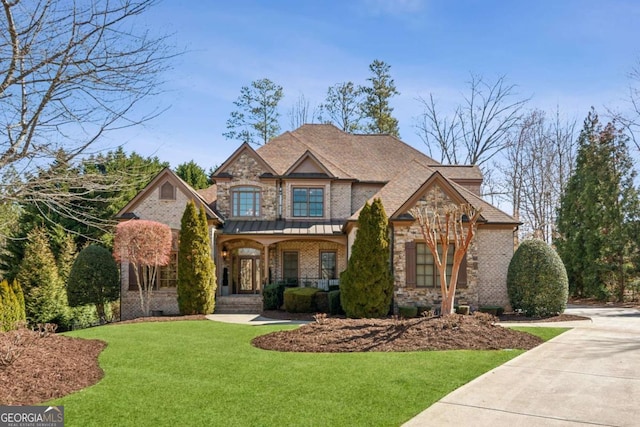 view of front of property with covered porch, brick siding, stone siding, crawl space, and a front lawn