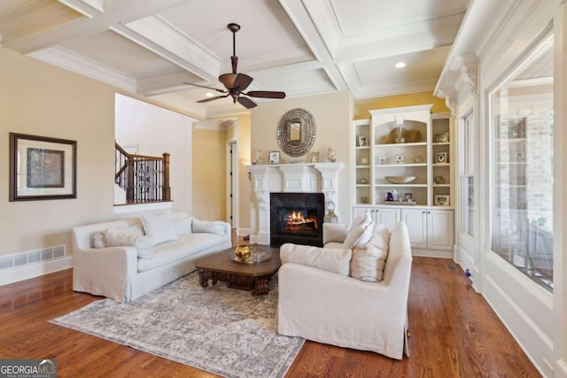 living area featuring visible vents, coffered ceiling, stairway, wood finished floors, and beam ceiling