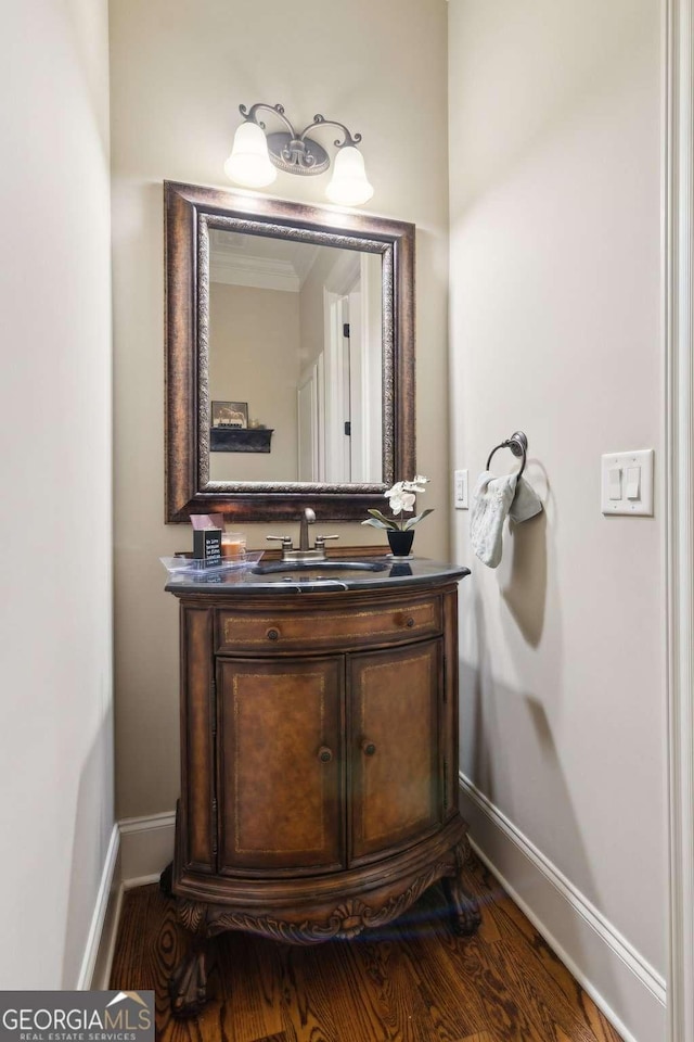 bathroom with wood finished floors, vanity, and baseboards