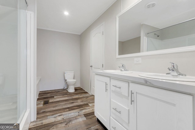 bathroom with a shower, wood finished floors, a sink, and toilet