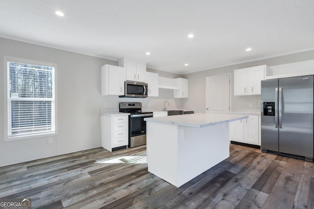 kitchen with a center island, light countertops, appliances with stainless steel finishes, dark wood-type flooring, and white cabinetry