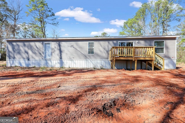 back of house featuring stairs and a wooden deck