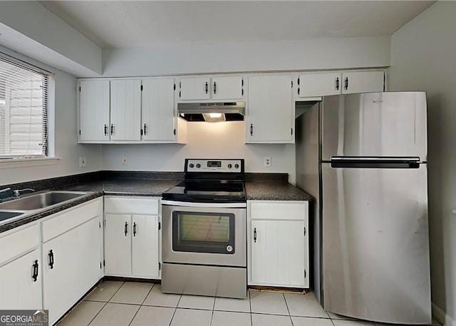 kitchen with stainless steel appliances, dark countertops, light tile patterned flooring, and under cabinet range hood