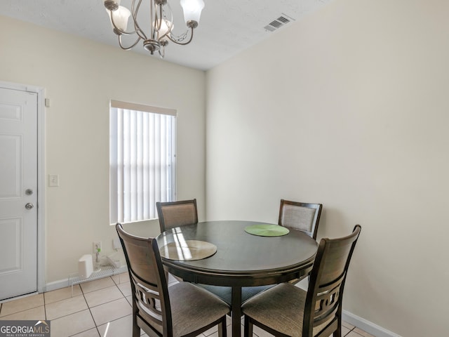 dining space with visible vents, a notable chandelier, baseboards, and light tile patterned floors