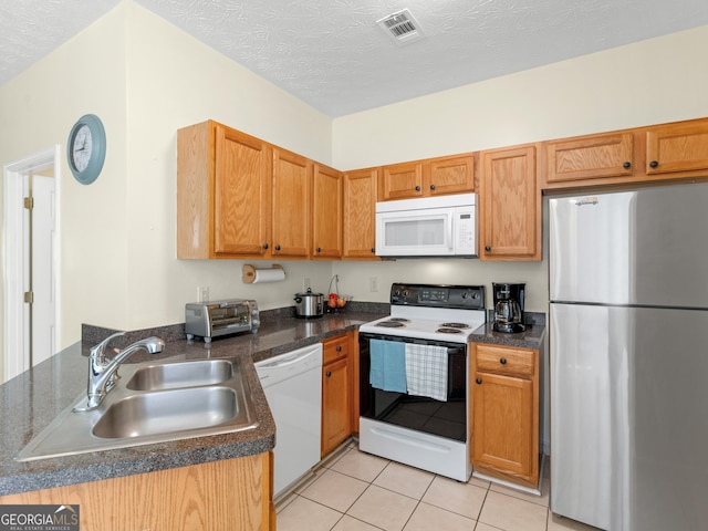 kitchen with light tile patterned floors, visible vents, a sink, a textured ceiling, and white appliances