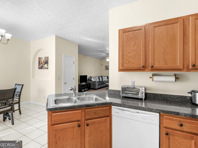 kitchen with light tile patterned floors, a peninsula, white dishwasher, a textured ceiling, and a sink