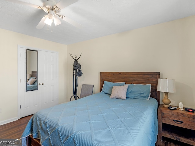 bedroom featuring a ceiling fan, a closet, baseboards, and wood finished floors