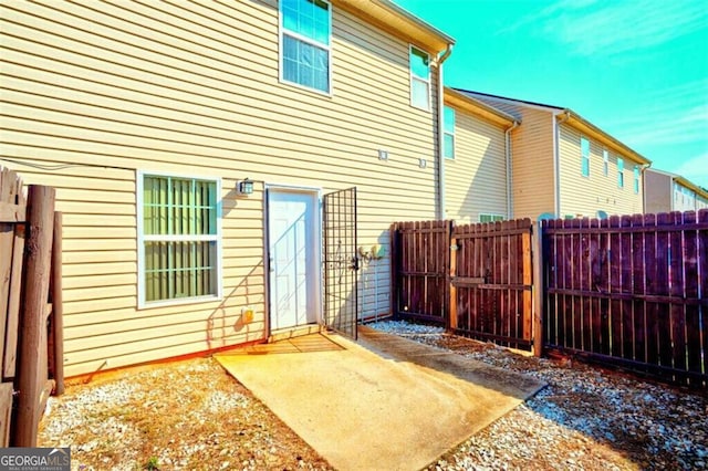 rear view of property featuring fence and a patio