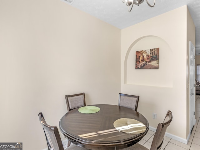 dining area with a notable chandelier, baseboards, and light tile patterned floors