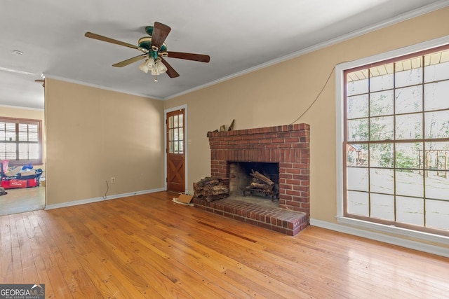 living area featuring a brick fireplace, baseboards, ornamental molding, and hardwood / wood-style floors