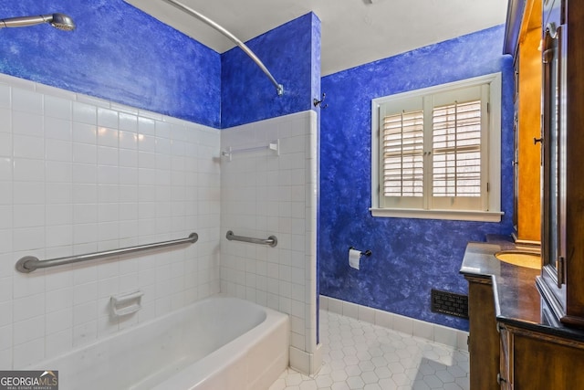 bathroom featuring wallpapered walls, baseboards, tile patterned flooring, vanity, and washtub / shower combination