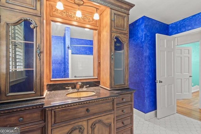 bathroom featuring tile patterned flooring, baseboards, and vanity