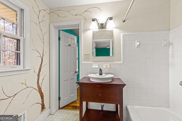 bathroom featuring bathtub / shower combination, tile walls, and vanity