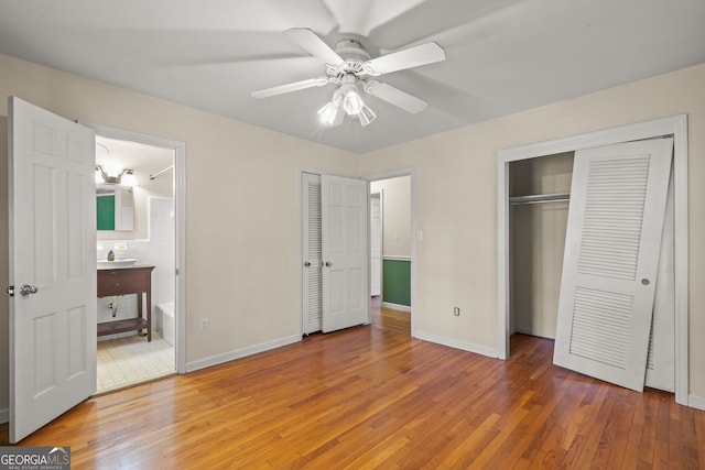 unfurnished bedroom featuring light wood finished floors, ceiling fan, baseboards, and connected bathroom