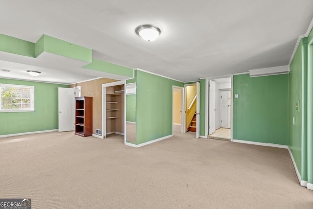 unfurnished bedroom featuring baseboards, carpet, and crown molding