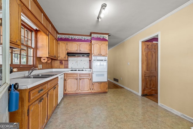 kitchen featuring white appliances, a sink, visible vents, light countertops, and crown molding