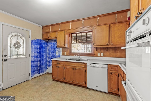 kitchen featuring crown molding, white appliances, light countertops, and a sink