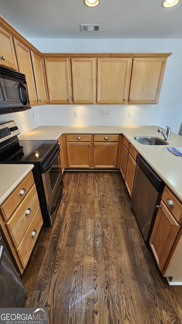 kitchen featuring visible vents, dark wood-style floors, appliances with stainless steel finishes, light countertops, and a sink