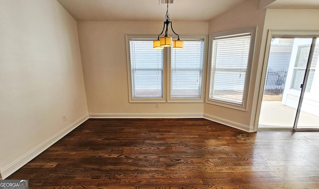 unfurnished dining area featuring visible vents, dark wood finished floors, and baseboards