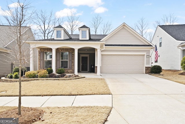 view of front of house with covered porch, concrete driveway, and an attached garage