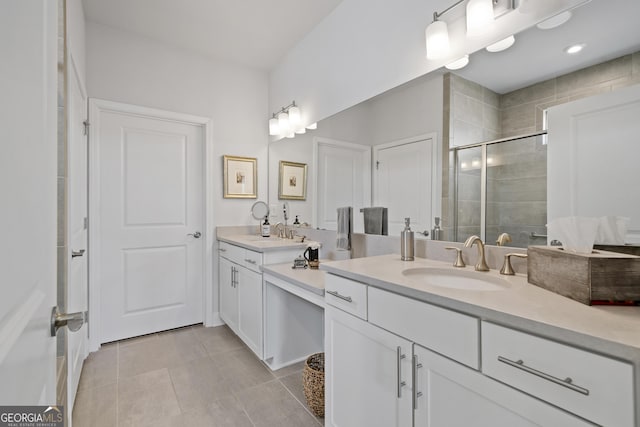 bathroom featuring double vanity, a stall shower, tile patterned flooring, and a sink