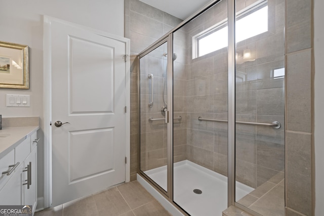 full bath with a stall shower, tile patterned flooring, and vanity