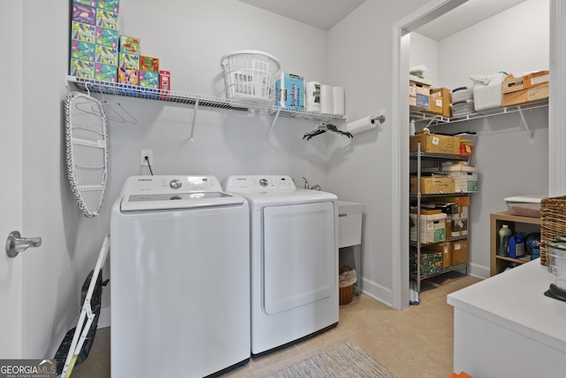 laundry area featuring laundry area, tile patterned floors, baseboards, and washing machine and clothes dryer