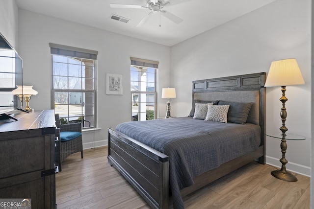 bedroom featuring a ceiling fan, light wood-style flooring, visible vents, and baseboards