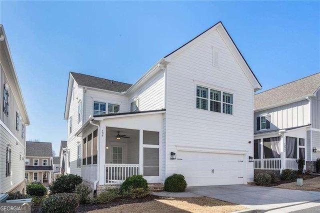 traditional home with driveway, an attached garage, and a sunroom