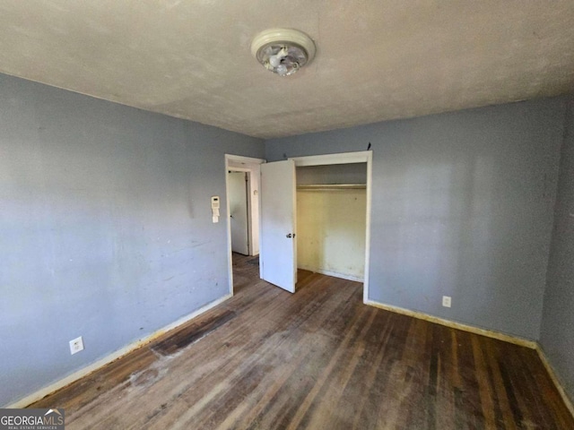 unfurnished bedroom featuring a closet, baseboards, and wood finished floors