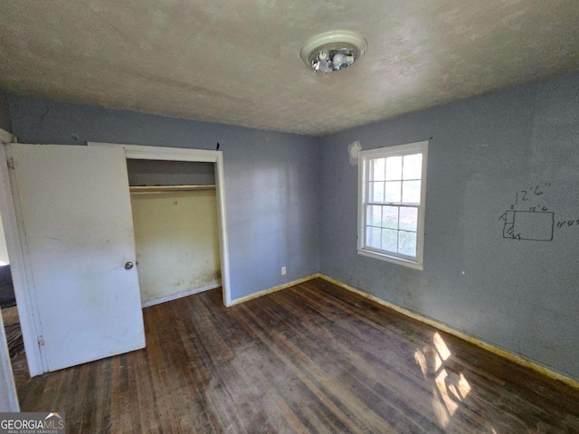 unfurnished bedroom featuring a closet, baseboards, and wood finished floors