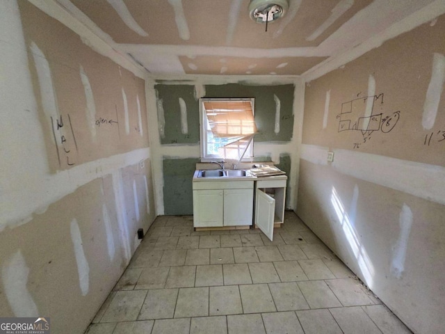 kitchen featuring white cabinetry and a sink