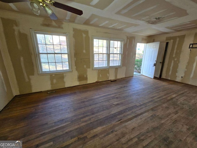 unfurnished room with ceiling fan, dark wood-type flooring, and plenty of natural light