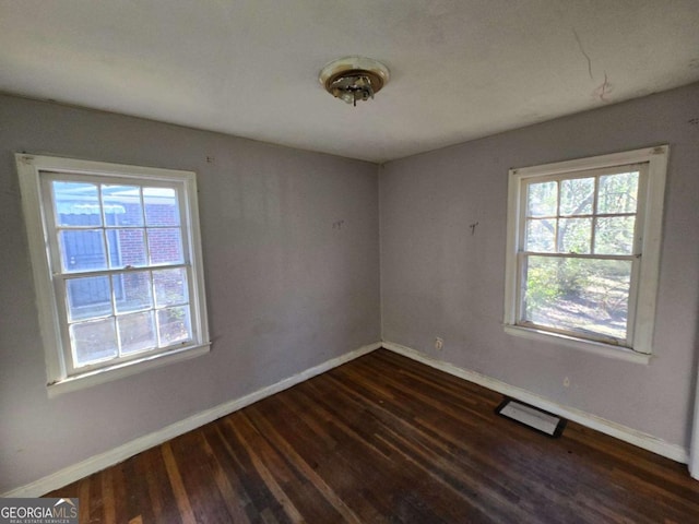 empty room with dark wood finished floors and baseboards