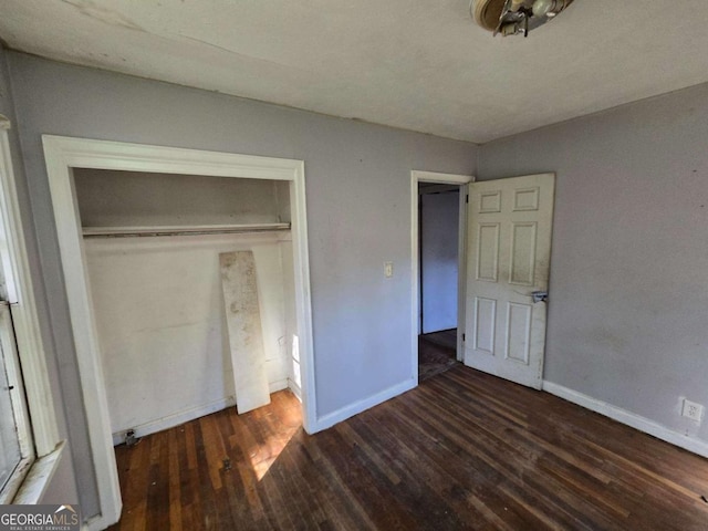 unfurnished bedroom with a closet, wood finished floors, and baseboards