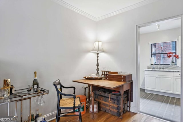 living area featuring crown molding, baseboards, and wood finished floors