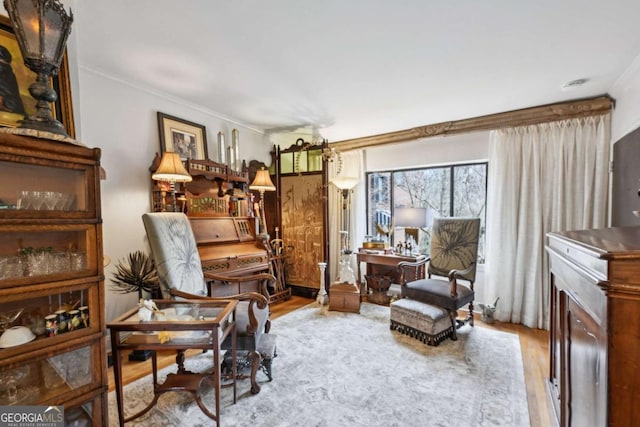 sitting room featuring ornamental molding and wood finished floors