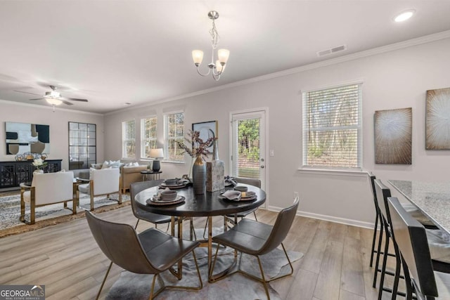 dining area featuring light wood-type flooring, crown molding, and baseboards